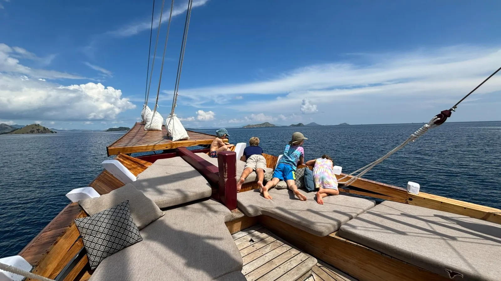 Kids sitting at the bow of liveaboard boat Vinca, Komodo National Park Indonesia