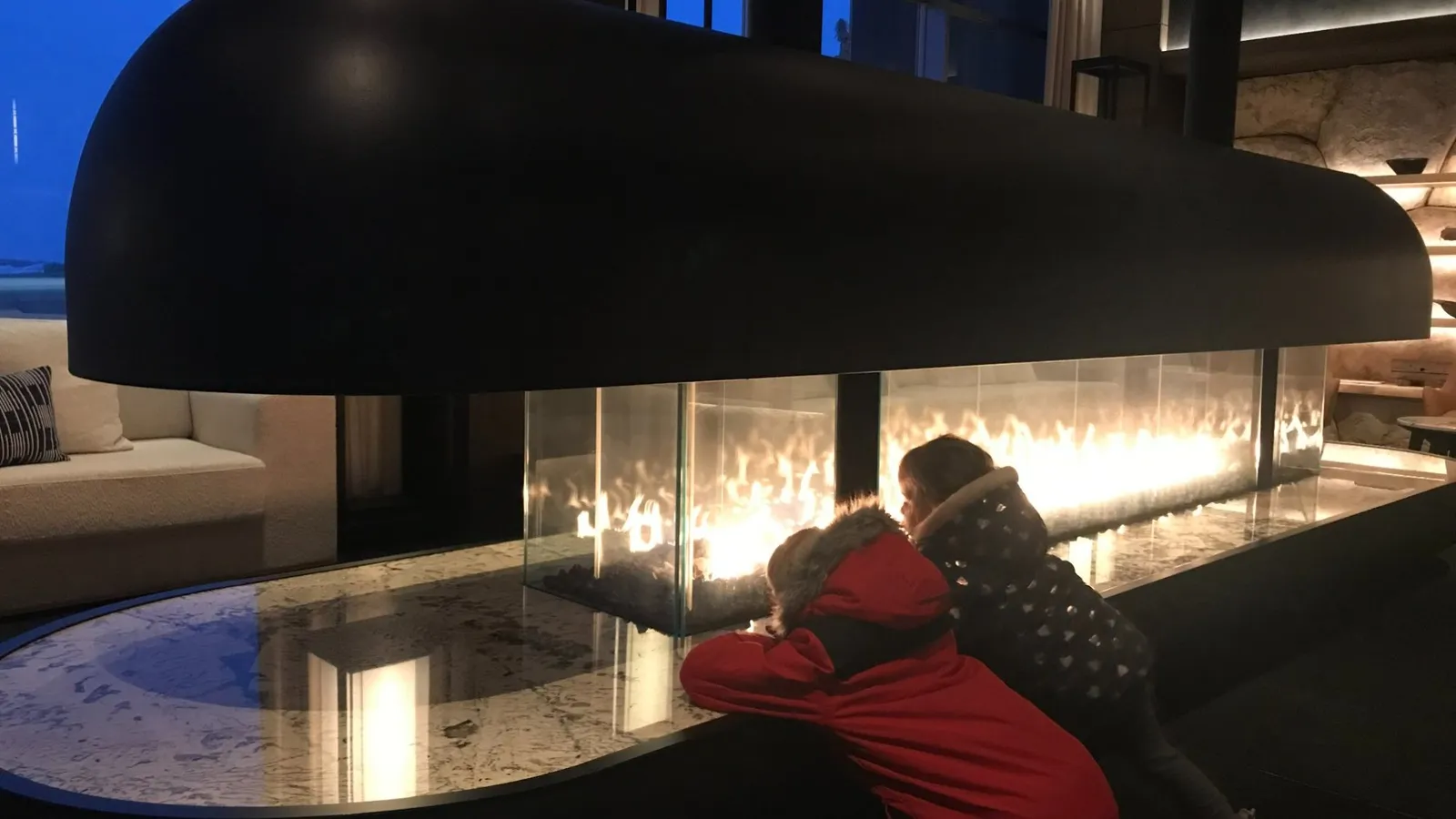 Setsu Niseko hotel lobby with fireplace, kids warming up after skiing