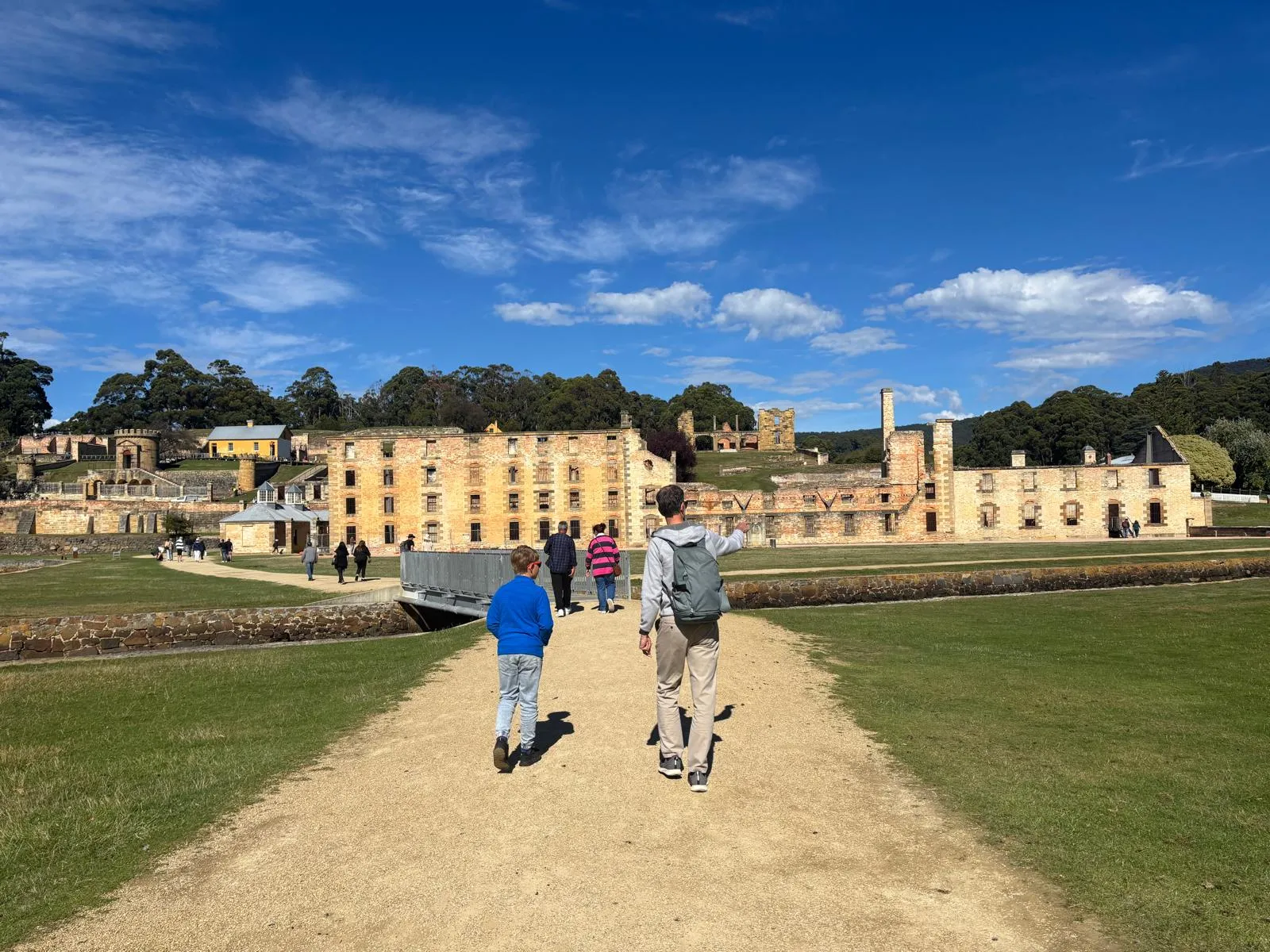 Father and son walking toward the convict ruins at Port Arthur historic site, Tasmania